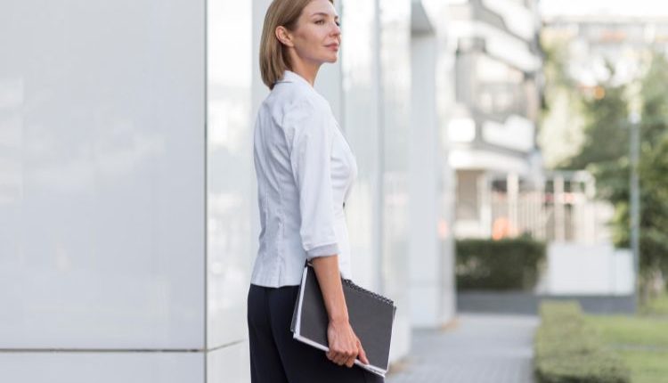 Donna indossa camicia e pantalone in un look formale e professionale, pronta per trasformare il suo outfit da ufficio in look da sera.