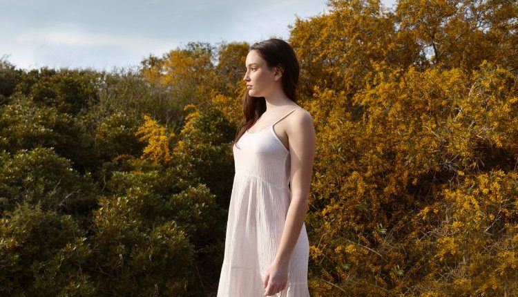 Donna che indossa un abito lungo da giorno immersa nella natura in estate.