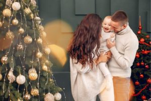 Famiglia vicino albero di Natale, con outfit coordinati con tonalità beige