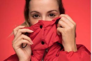 Donna che si copre con giubbino, seguendo la moda a strati