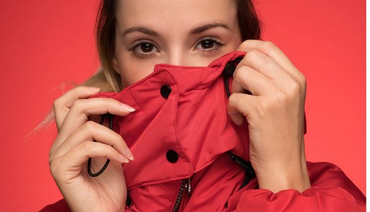 Donna che si copre con giubbino, seguendo la moda a strati